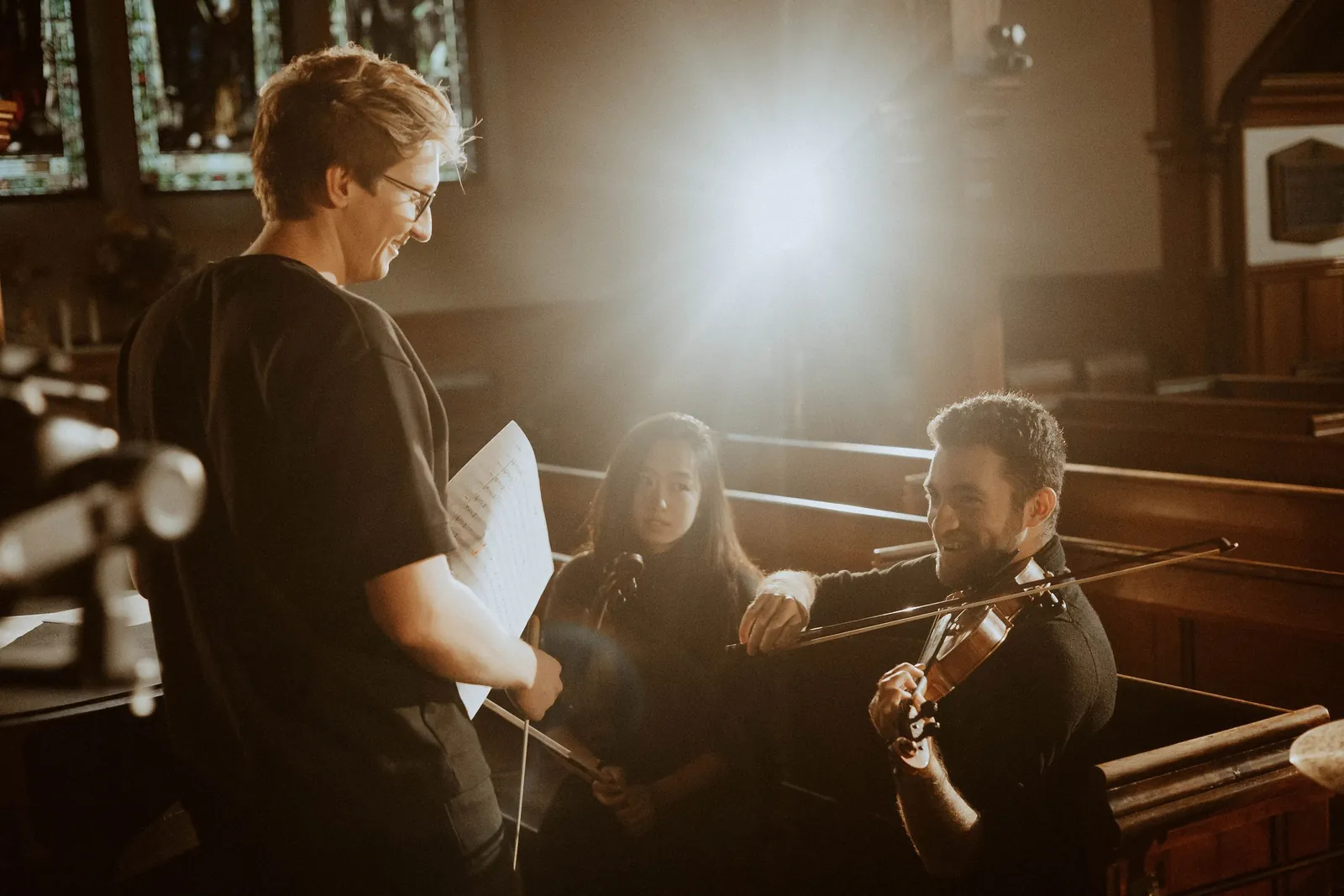 Sam rehearsing with a violinist and cellist